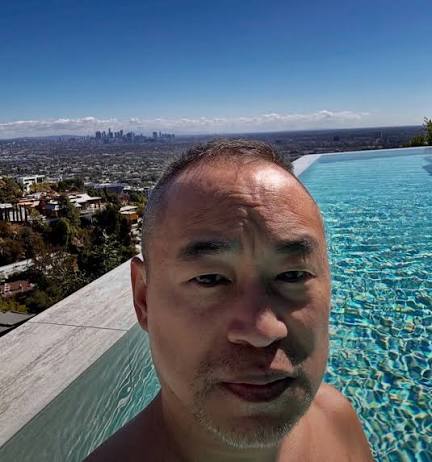 Machi Big Brother selfie by a pool overlooking Los Angeles